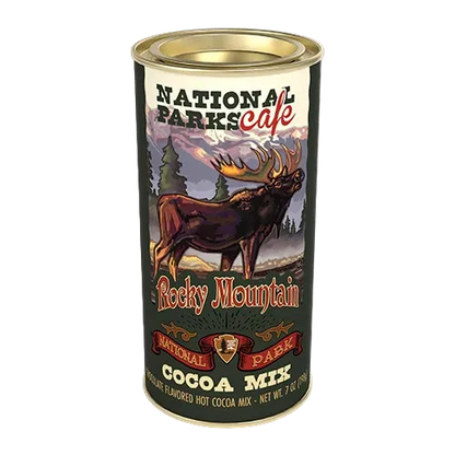 A cylindrical metal can of National Parks Cafe Rocky Mountain Cocoa Mix, featuring a label with an illustration of a moose in a mountain landscape.
