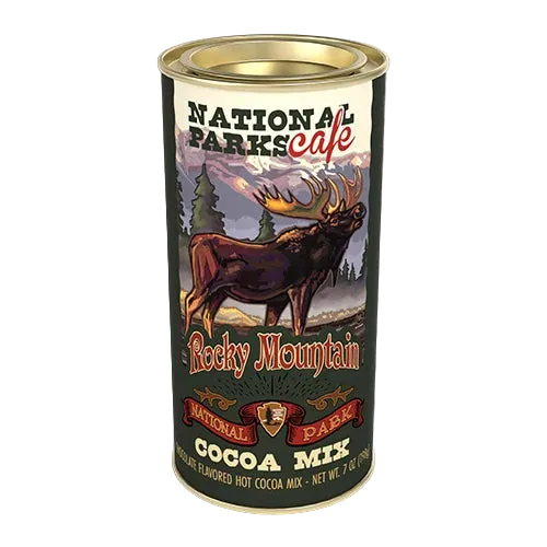 A cylindrical metal can of National Parks Cafe Rocky Mountain Cocoa Mix, featuring a label with an illustration of a moose in a mountain landscape.